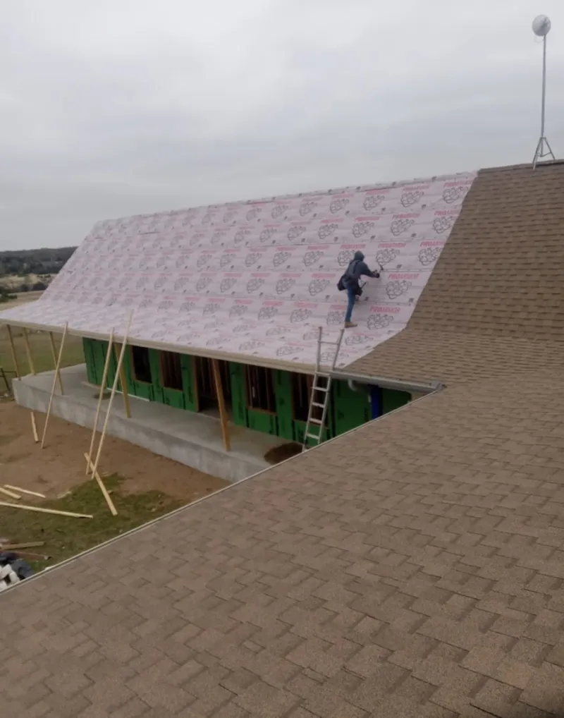 Worker preparing underlayment for a metal roof installation in Lathrop